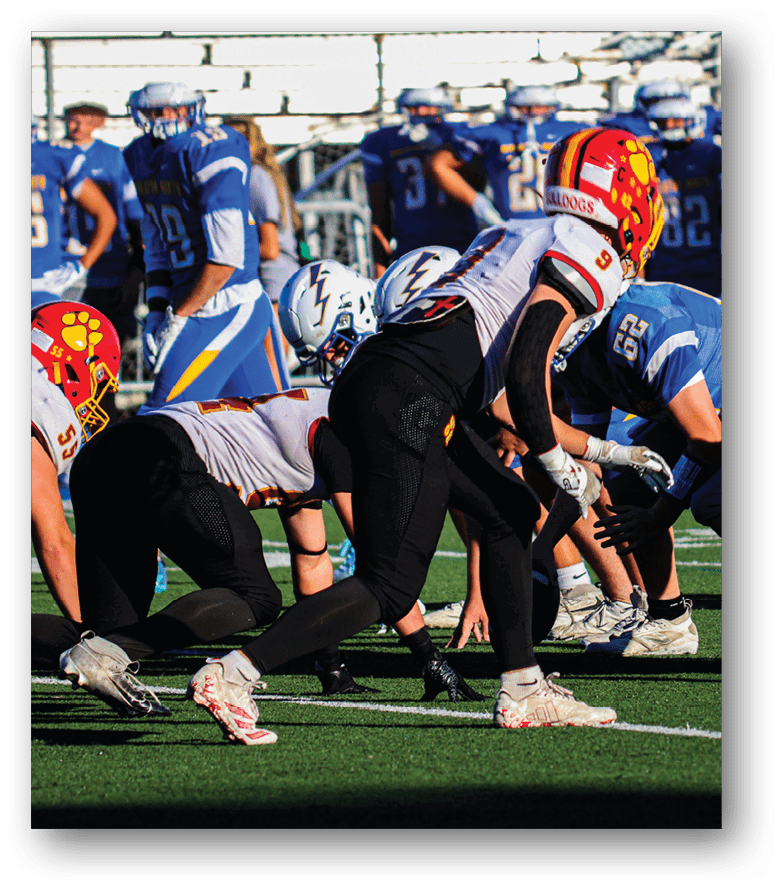 Three football players in blue and white uniforms running on a field. Description generated by AI