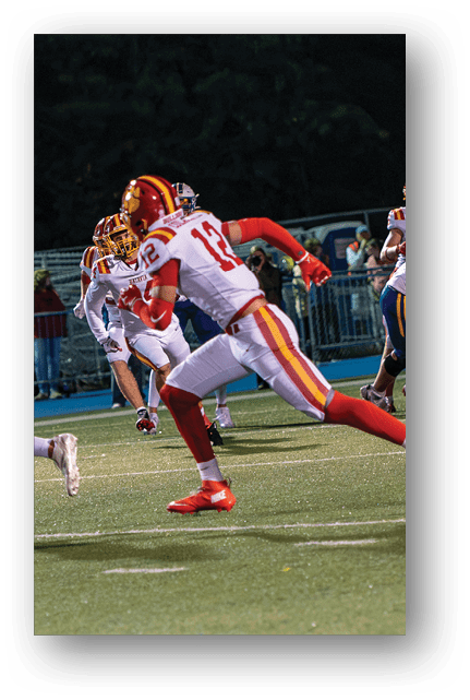 Two football players wearing blue and white uniforms. Description generated by AI
