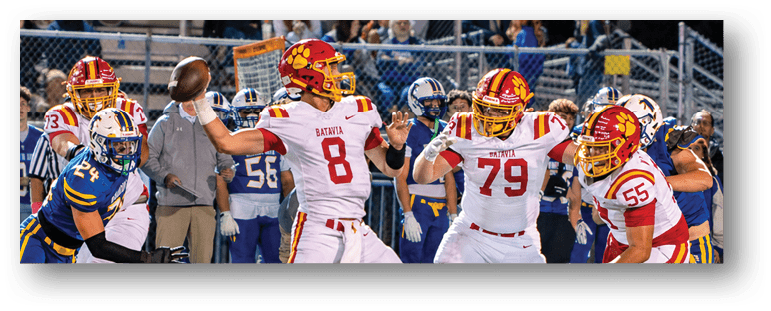 A football game is taking place on a field with players wearing blue and white uniforms. Description generated by AI