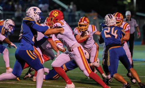 Two men wearing football uniforms are hugging each other on a field. AI generated content