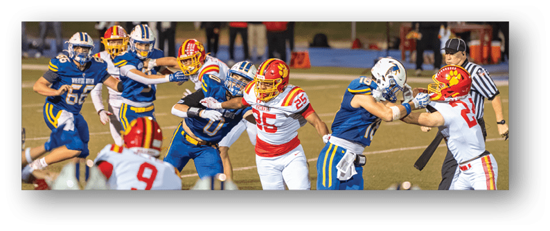 A football game is taking place on a field with players wearing blue and white uniforms. Description generated by AI