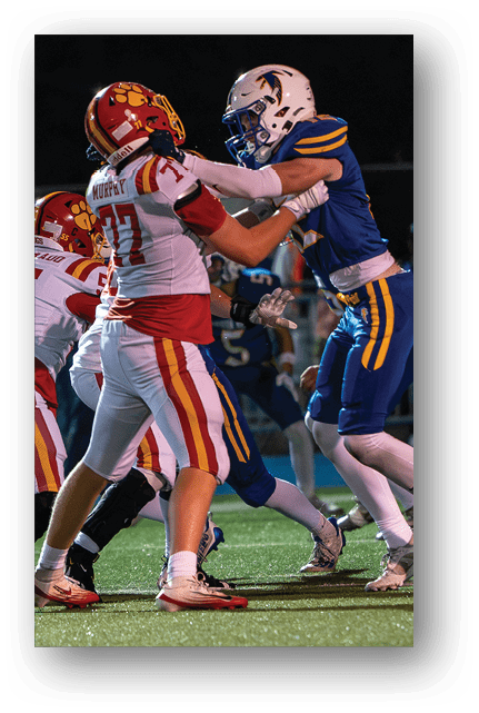 Two football players wearing blue and white uniforms. Description generated by AI