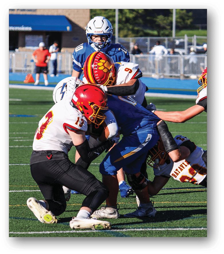 Three football players in blue and white uniforms running on a field. Description generated by AI