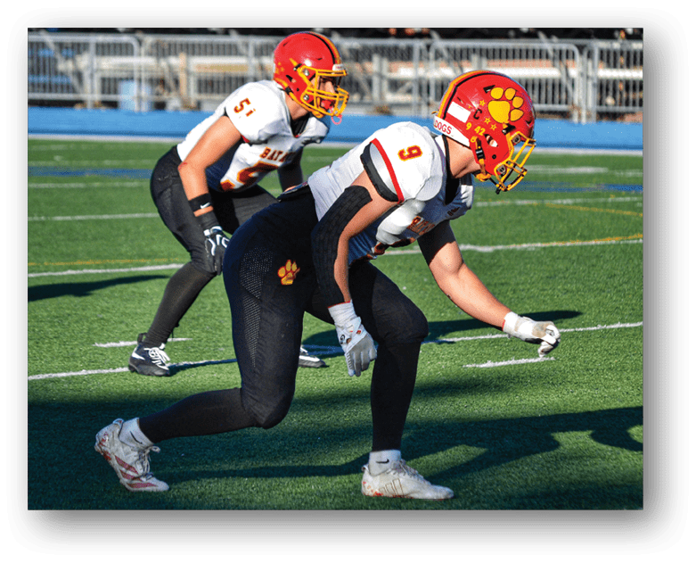 Three football players in blue and white uniforms running on a field. Description generated by AI