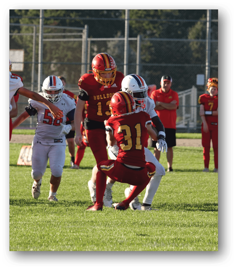 Three football players in blue and white uniforms running on a field. Description generated by AI