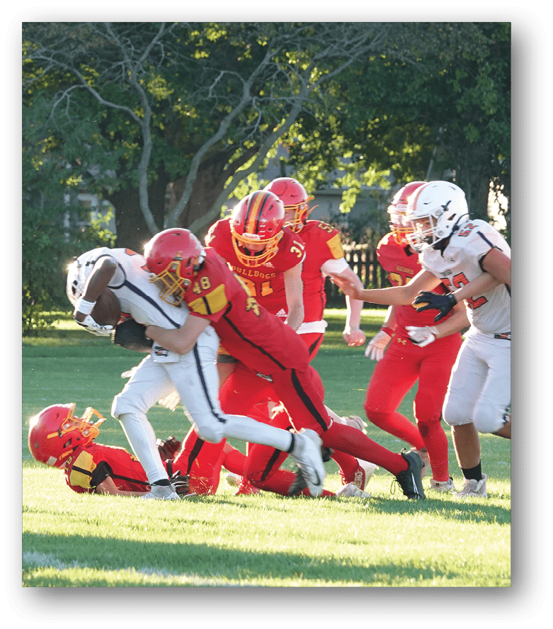 Three football players in blue and white uniforms running on a field. Description generated by AI