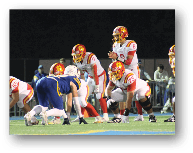 A football game is taking place on a field with players wearing blue and white uniforms. Description generated by AI