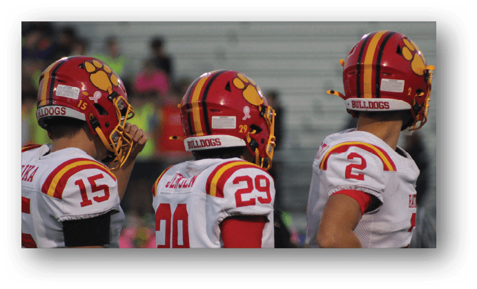 A group of football players on a field. Description generated by AI