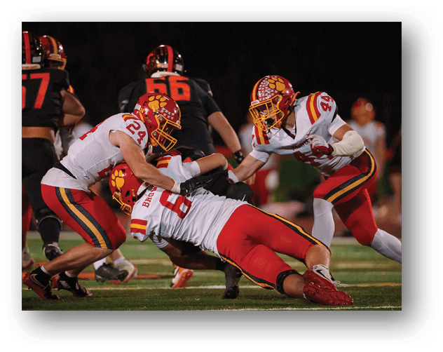A football game is taking place on a field with players wearing blue and white uniforms. Description generated by AI