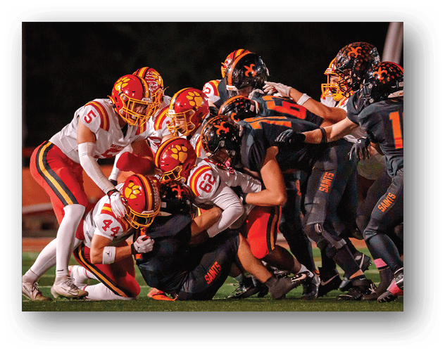 A football game is taking place on a field with players wearing blue and white uniforms. Description generated by AI