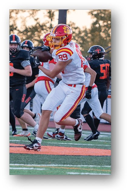 A football player catching a ball. Description generated by AI