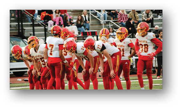 A group of football players on a field. Description generated by AI