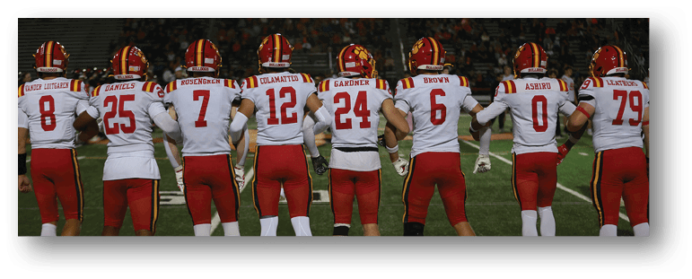 A football game is taking place on a field with players wearing blue and white uniforms. Description generated by AI