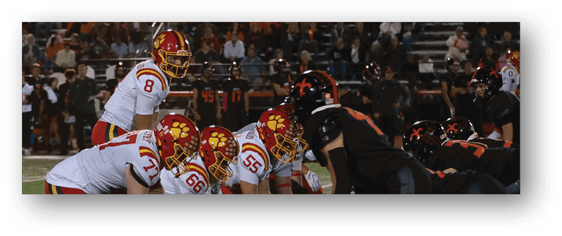A football game is taking place on a field with players wearing blue and white uniforms. Description generated by AI