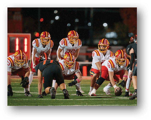 A football game is taking place on a field with players wearing blue and white uniforms. Description generated by AI