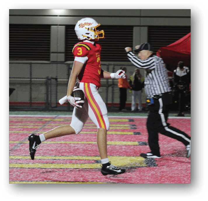 Three football players in blue and white uniforms running on a field. Description generated by AI