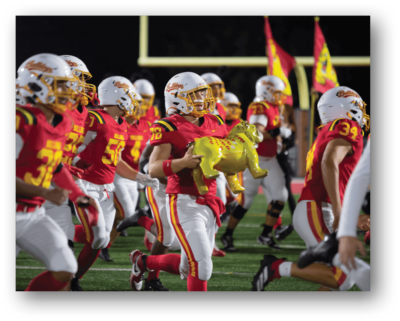 A group of football players on a field. Description generated by AI