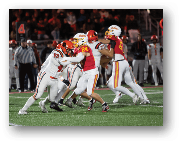 A football game is taking place on a field with players wearing blue and white uniforms. Description generated by AI