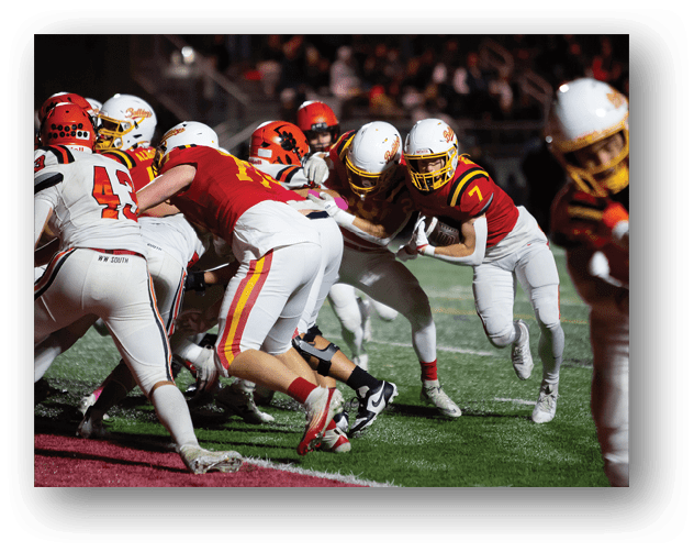 A football game is taking place on a field with players wearing blue and white uniforms. Description generated by AI