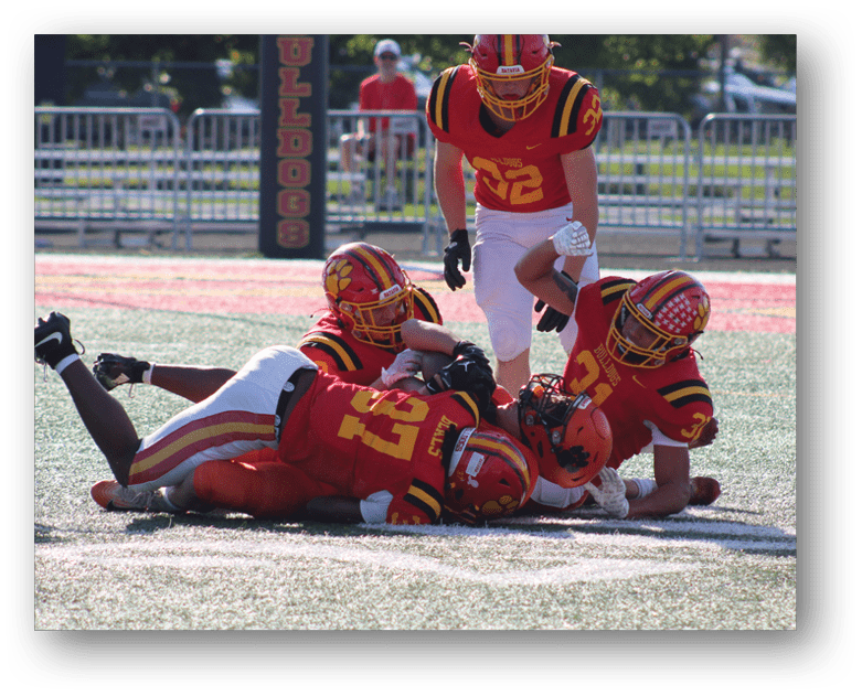 Three football players in blue and white uniforms running on a field. Description generated by AI