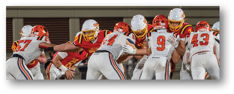A football game is taking place on a field with players wearing blue and white uniforms. Description generated by AI