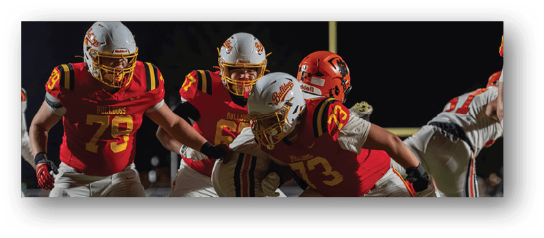 A group of football players on a field. Description generated by AI