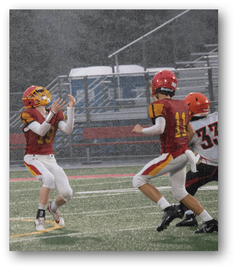 Three football players in blue and white uniforms running on a field. Description generated by AI