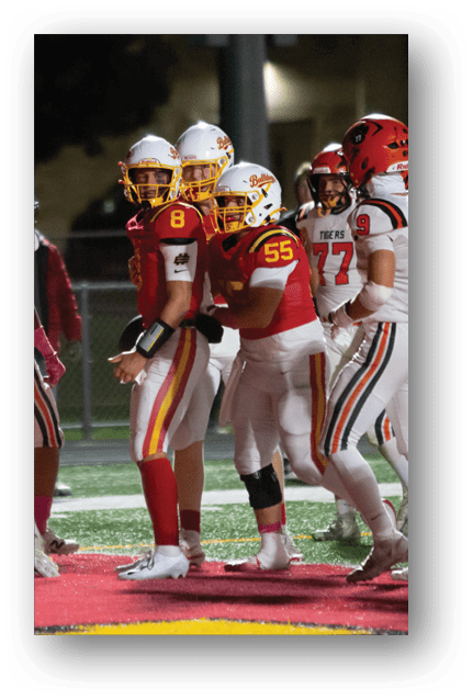 Two football players wearing blue and white uniforms. Description generated by AI