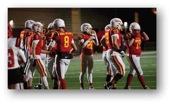 A group of football players on a field. Description generated by AI