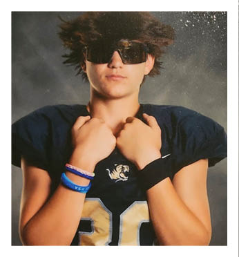 A football player wearing a black and gold jersey with the number 30 on it. Description generated by AI