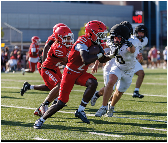 A football player running with a football. Description generated by AI