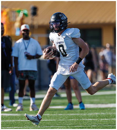 A man wearing a white jersey with the number 10 is running on a field. Description generated by AI