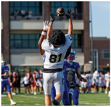 A football player catching a ball. Description generated by AI