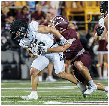 Two football players on a field. Description generated by AI