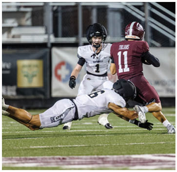 A football player in a white jersey is sliding on the ground. Description generated by AI