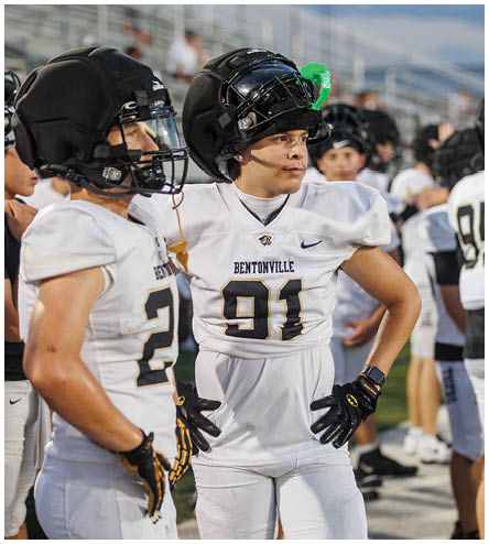 Two football players wearing white uniforms. Description generated by AI