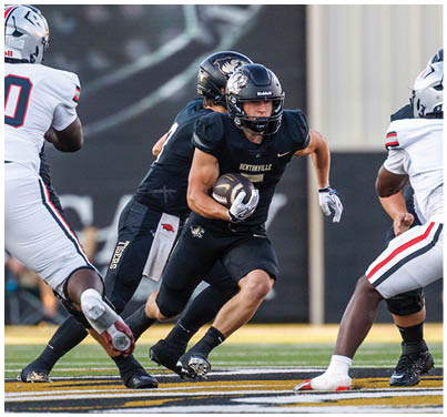 A football player running with the ball. Description generated by AI
