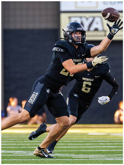 A football player catching a ball. Description generated by AI