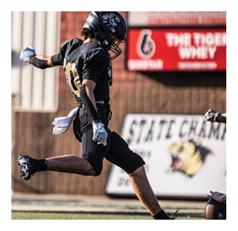 A football player in a black jersey with the number 8 on it. Description generated by AI