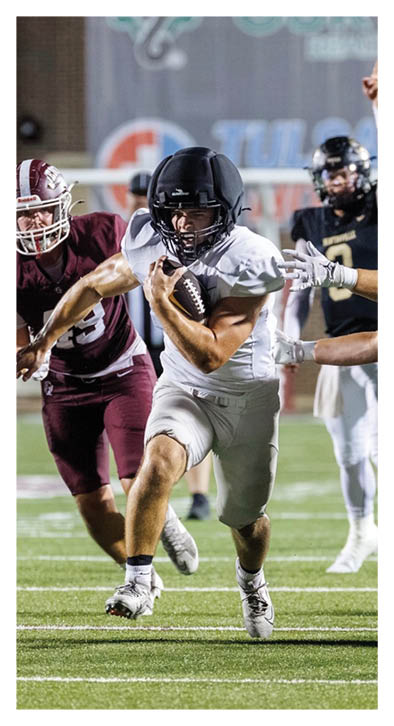 A football player running with a ball. Description generated by AI