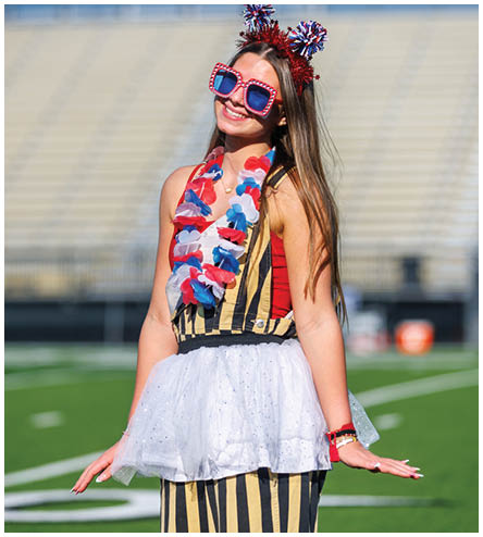 A woman wearing a red, white, and blue outfit and sunglasses. Description generated by AI