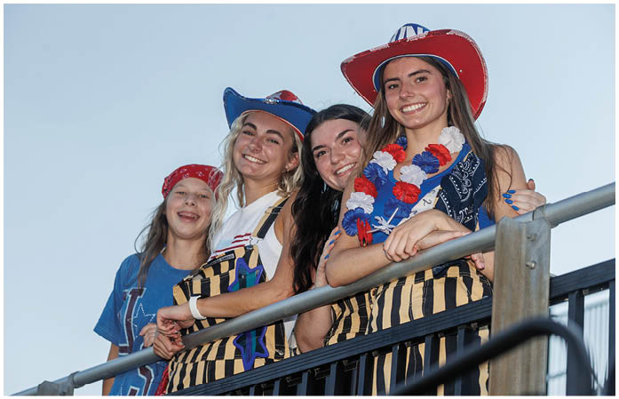 A group of girls wearing red, white, and blue hats. Description generated by AI