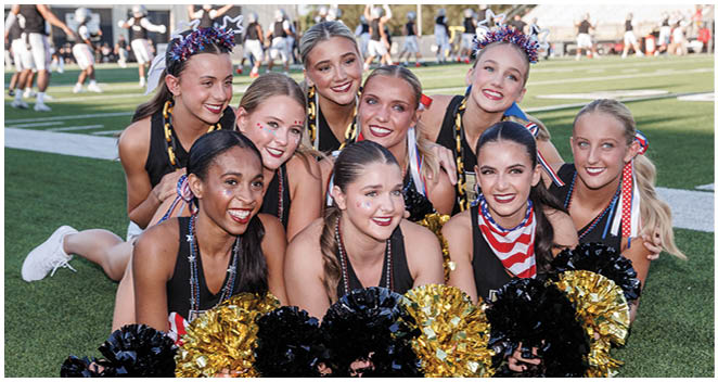 A group of cheerleaders posing for a picture. Description generated by AI
