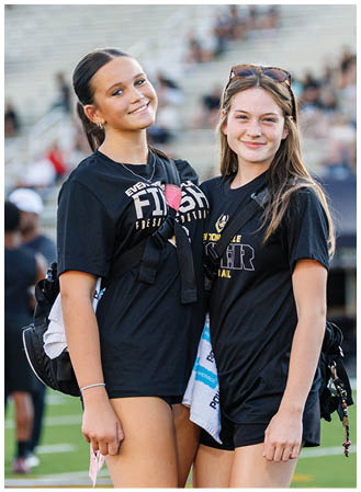 Two girls wearing black shirts and shorts. Description generated by AI