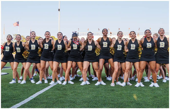 A group of cheerleaders in uniforms. Description generated by AI