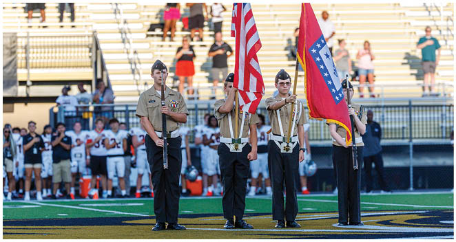 Three men in uniforms holding flags. Description generated by AI