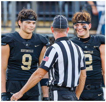 A man wearing a black and gold jersey with the number 9 on it. Description generated by AI