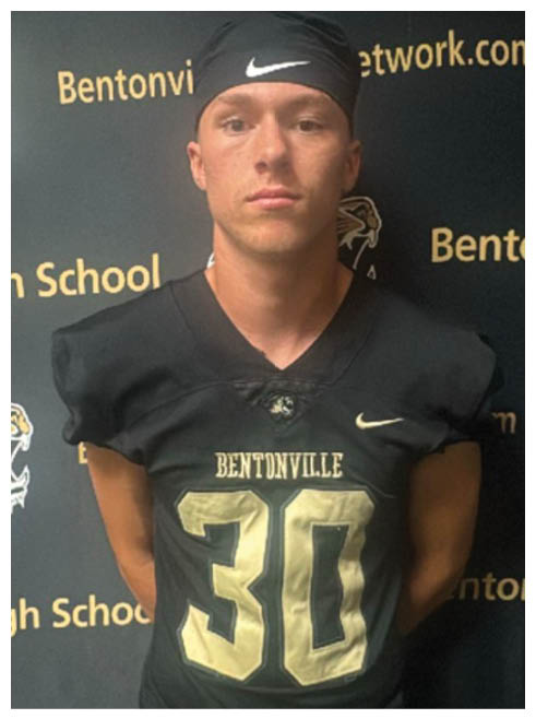A football player wearing a black and gold jersey with the number 30 on it. Description generated by AI