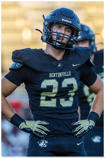 A football player wearing a black and gold jersey with the number 32 on it. Description generated by AI