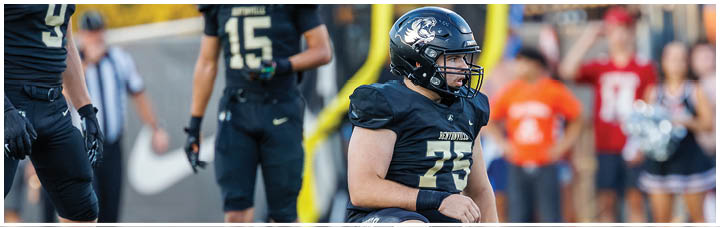 A football player kneeling on the ground. Description generated by AI